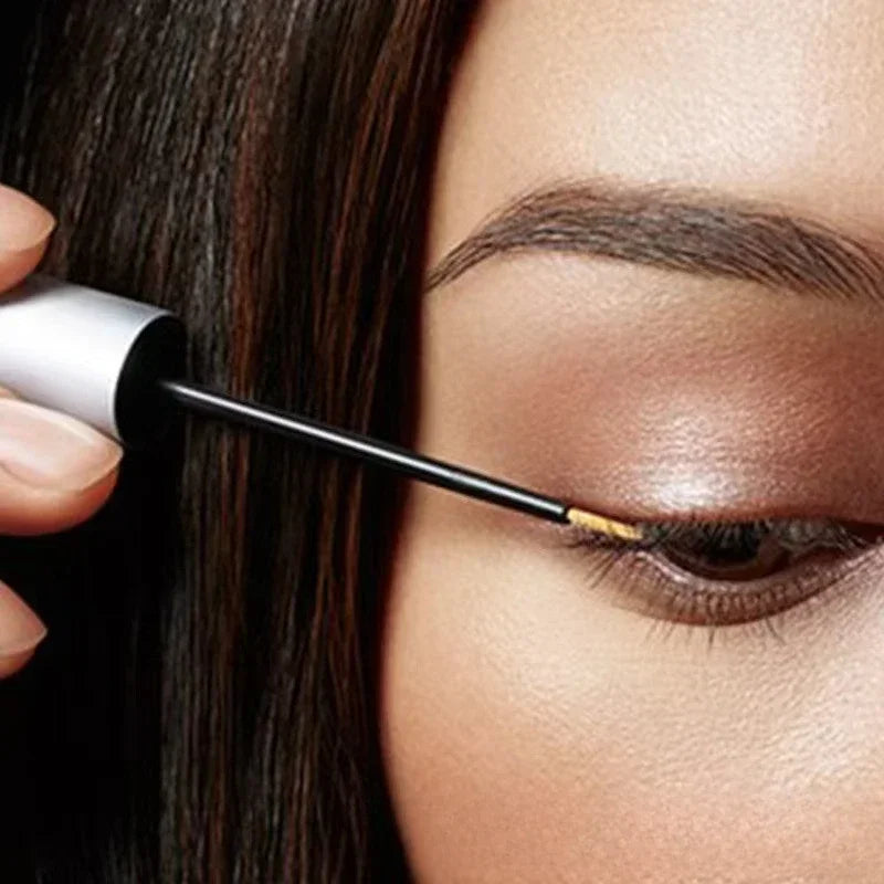 Person applying mascara to their eyelashes with a close-up focus on the eye area.