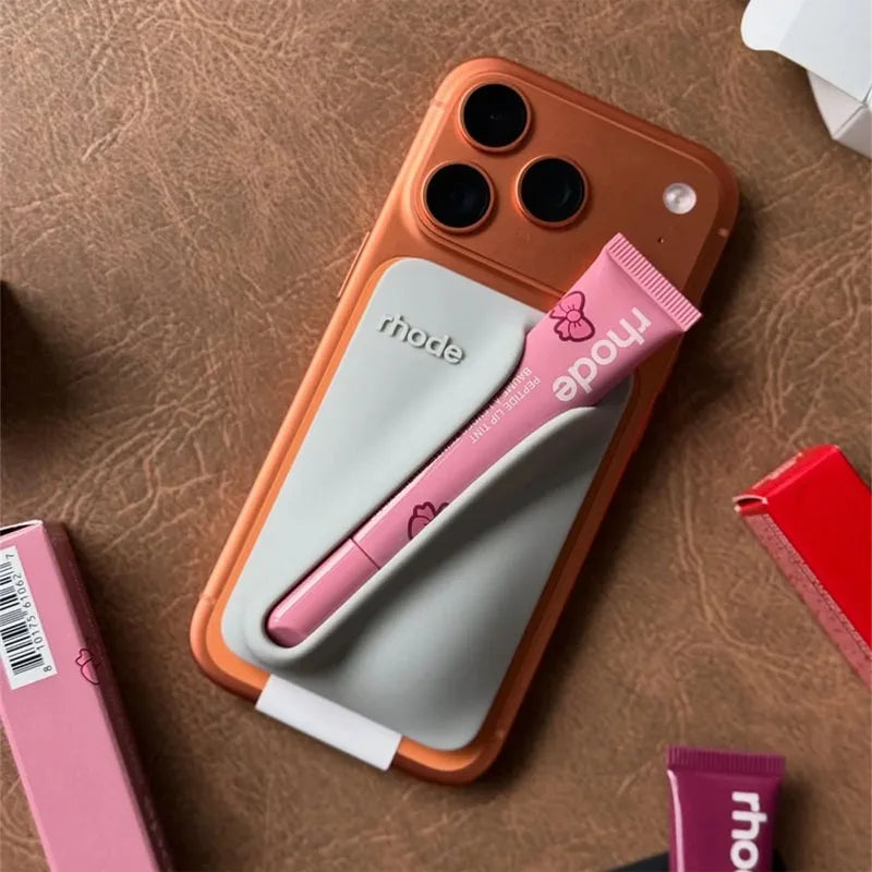 Phone case with pink and gray accents on a brown surface