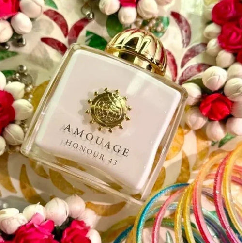 Amouage Honour 43 perfume bottle surrounded by colorful flowers and ribbons