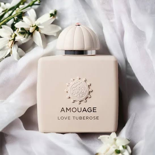 Amouage Love Tuberose perfume bottle with flowers on a light fabric background