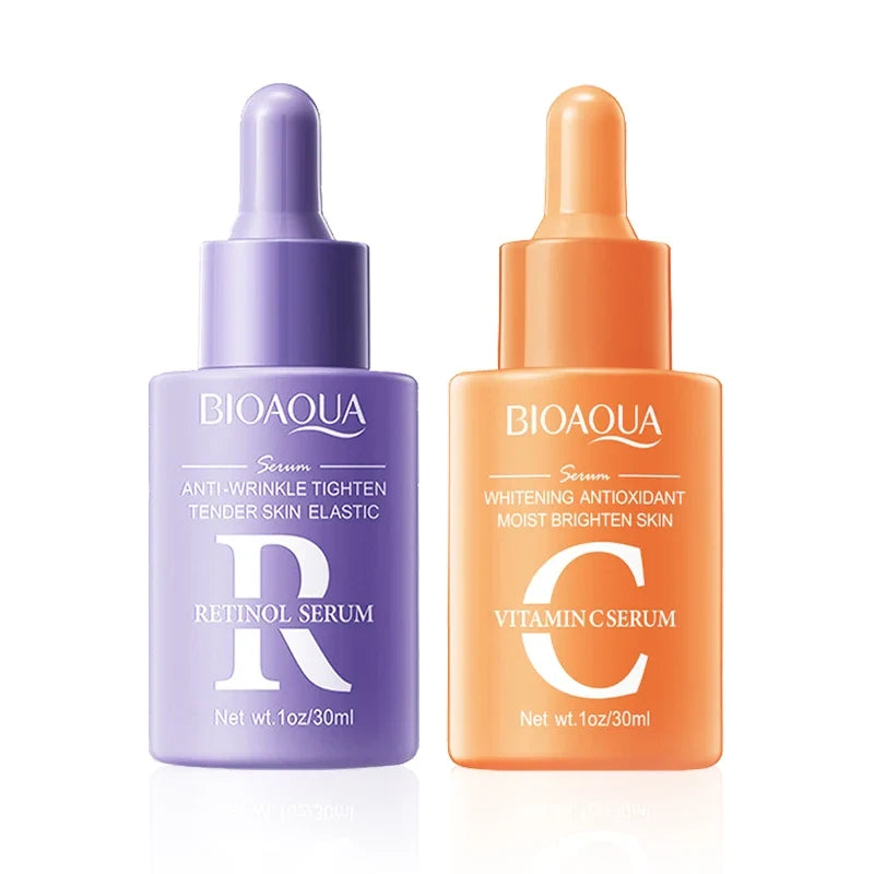 Two Bioaqua skincare serum bottles, one purple and one orange, on a white background.