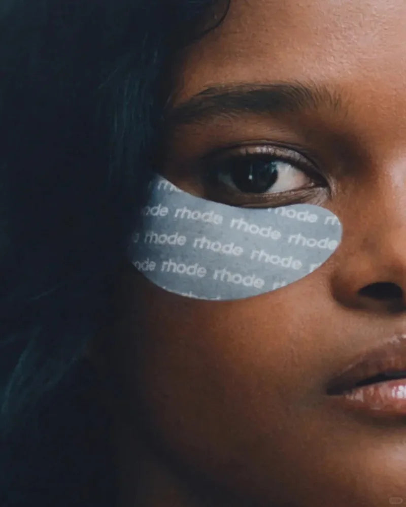 Close-up of a person wearing a face mask with 'rhode' branding.