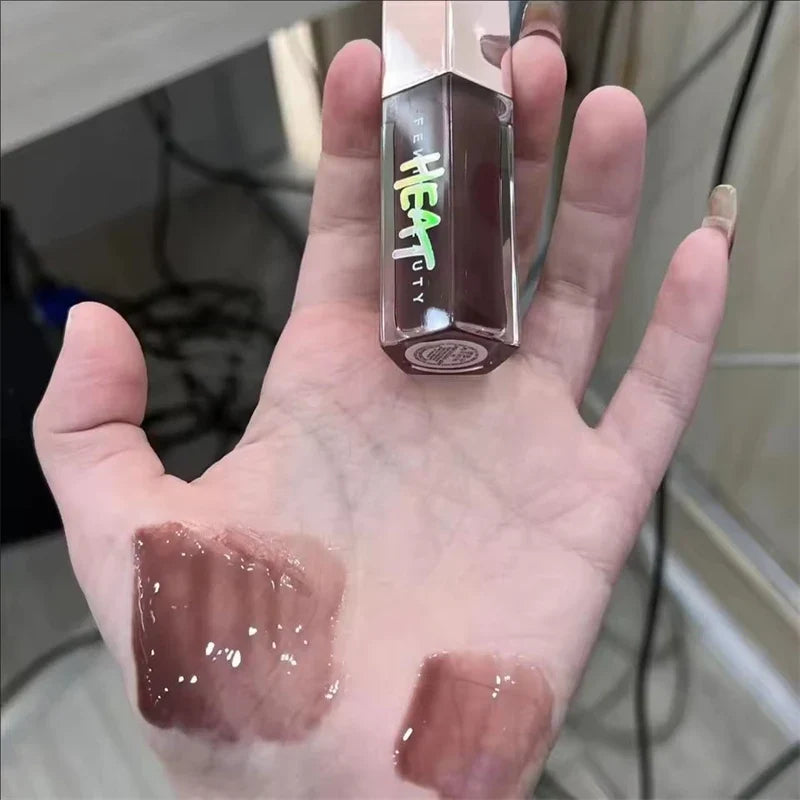 Hand holding a lipstick with visible color swatches on the palm