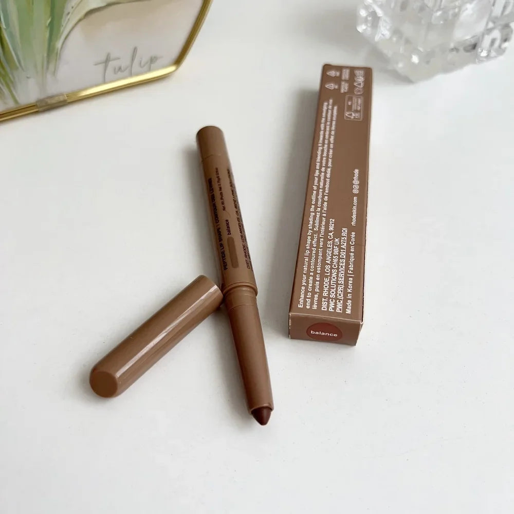 Brown makeup pencil with packaging on a white surface
