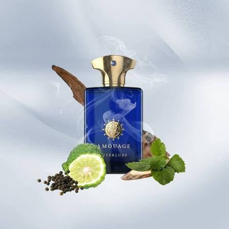 A blue rectangular perfume bottle with a gold cap, labeled Amouage Waterlude, centered against a soft light gray background with decorative botanical and spice props including a lime slice, peppercorns, mint leaves, and a cinnamon stick.