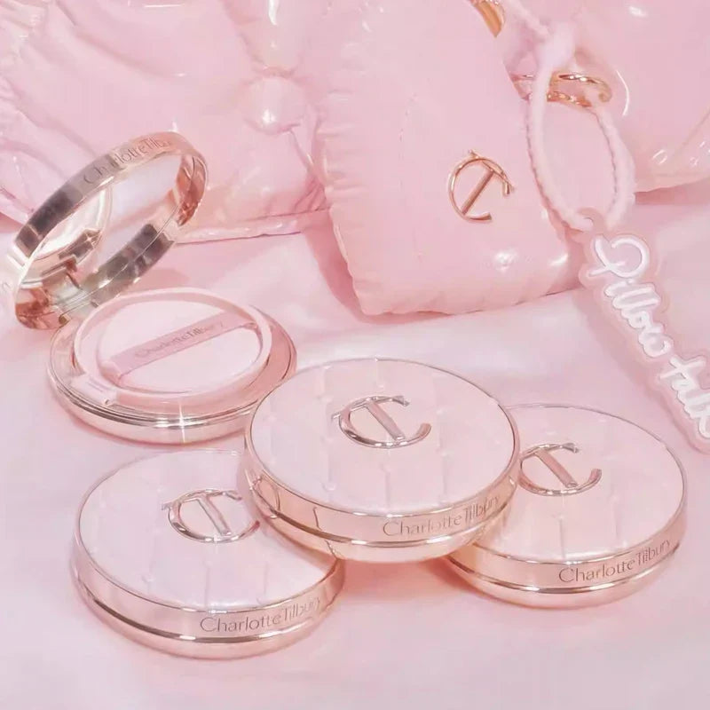 Makeup products with 'Charlotte Tilbury' branding on a pink background