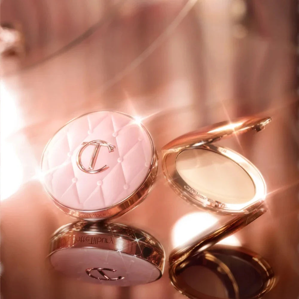 Two compact powder cases with a brand logo on a blurred background