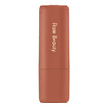Rare Beauty lipstick in a matte terracotta color with gold vertical branding on a clean white background.