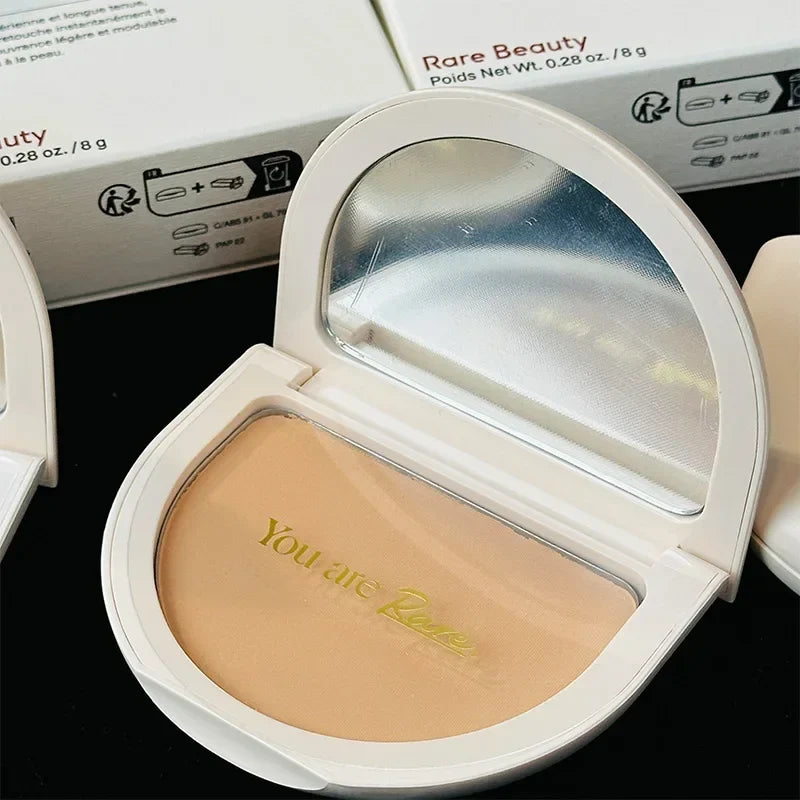 Compact powder with a mirror and 'Rare Beauty' branding on a black background