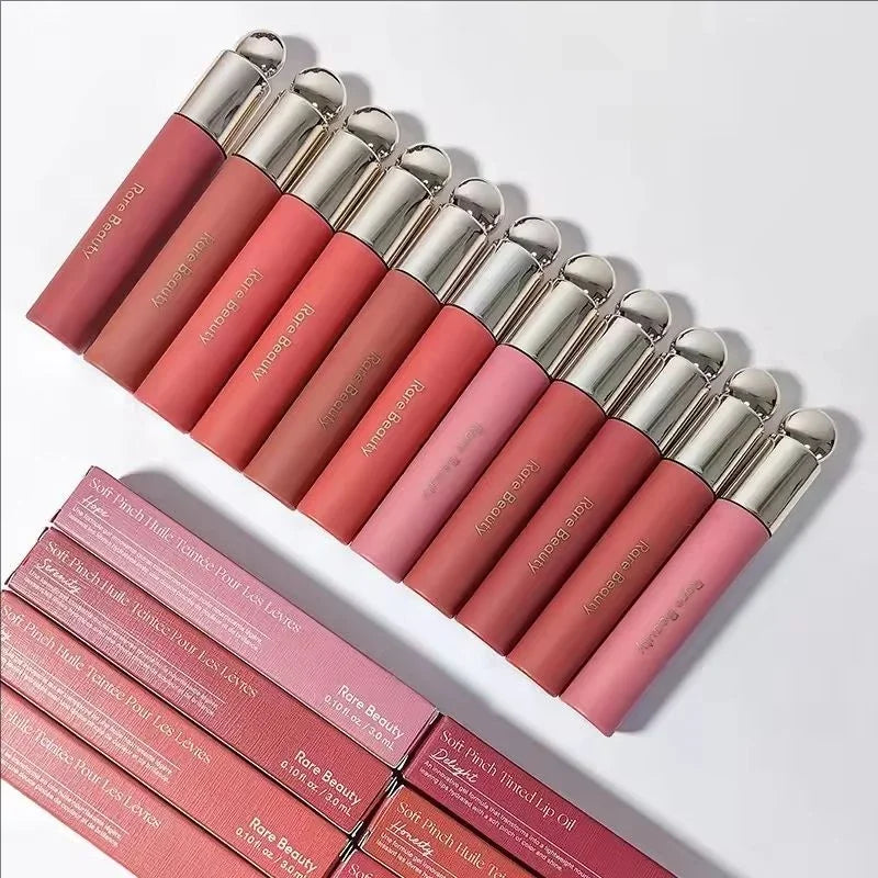 Set of pink lip glosses with silver caps on a white background