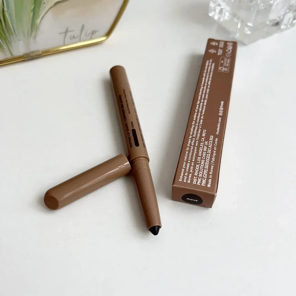 Brown makeup pencil with black cap and its packaging on a white surface.