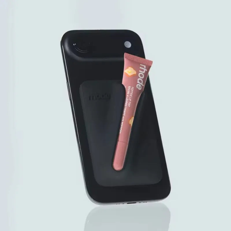 Black phone case with a pink lip balm on a light gray background