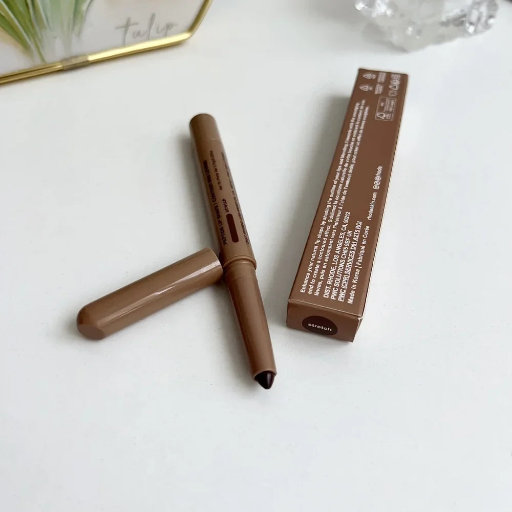 Brown makeup pencil with cap and packaging on a white surface