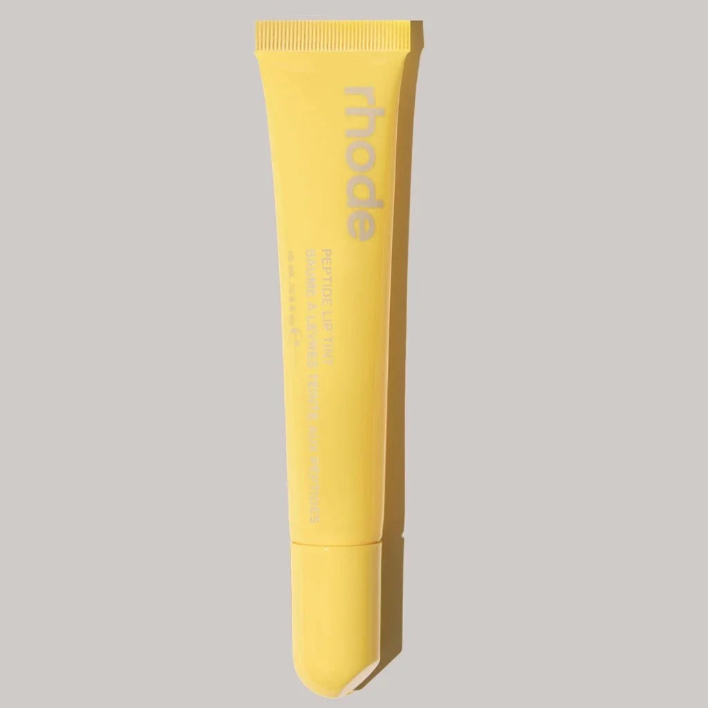 Yellow tube with 'rhode' branding on a gray background