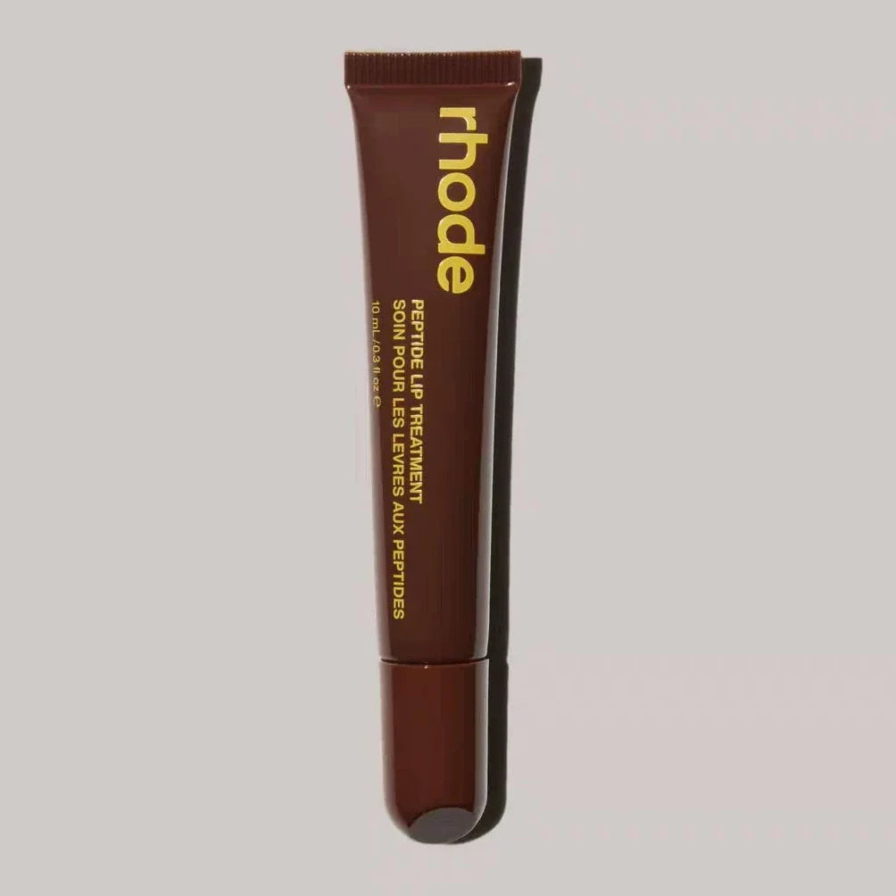 Brown lip treatment tube with 'rhode' branding on a gray background