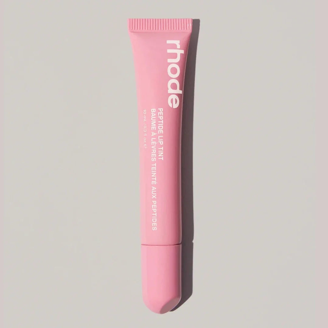 Pink lip balm tube with 'rhode' branding on a light gray background