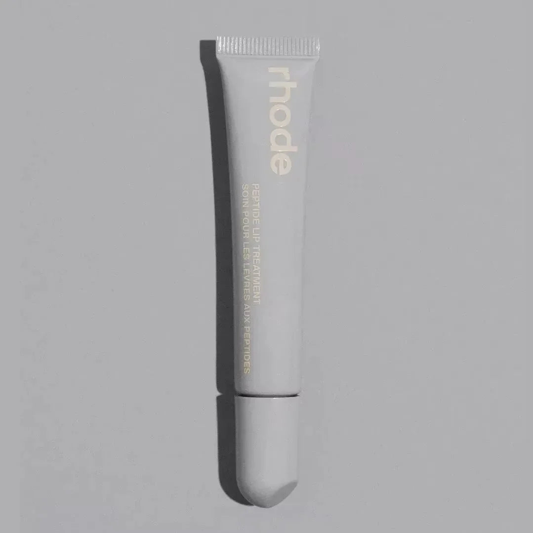 Skincare tube labeled 'rhode' on a gray background salted caramel 